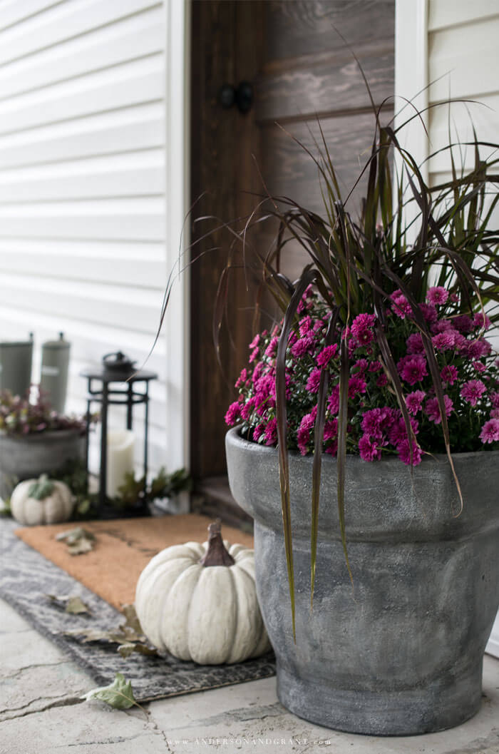 See how a farmhouse style front porch is decorated simply with purple mums.