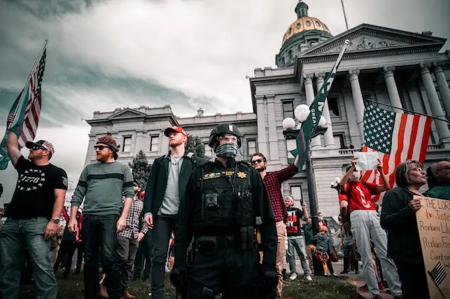 Group of men in black uniforms at Denver rally