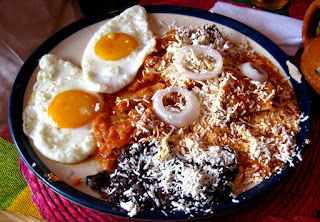 Chilaquiles rojos acompañados con frijoles y huevos