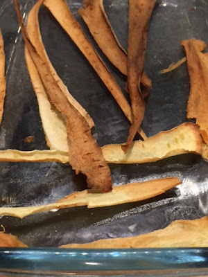 Cooked parsnip crisps in a glass dish