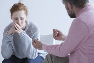 man speaking with distressed woman 