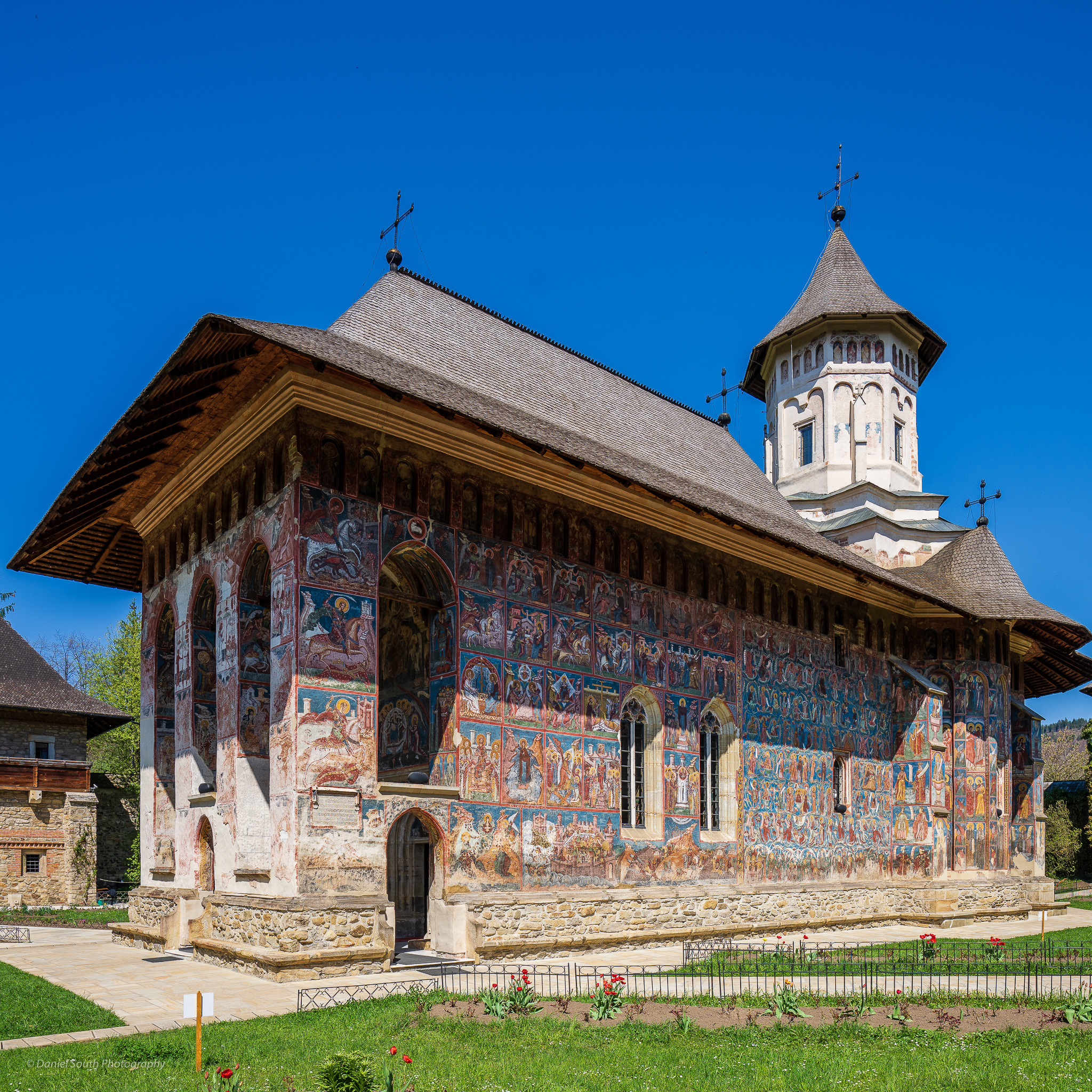 a photo of a monastery pained with outside fresco murals bucovina romania