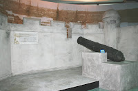 A cannon in a fort pointing to the river