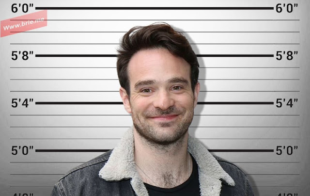 Charlie Cox standing in front of a height chart
