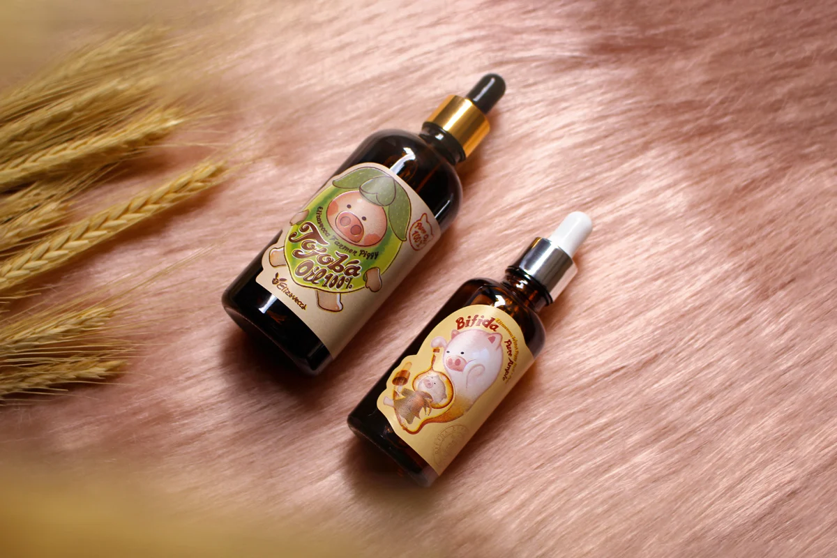 two skin care products by elizavecca in glass bottles are laying on top of a pink furry rug