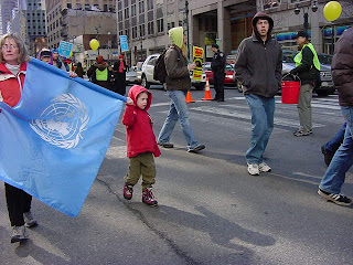 Photo: woman and child walking with the flag of the UN