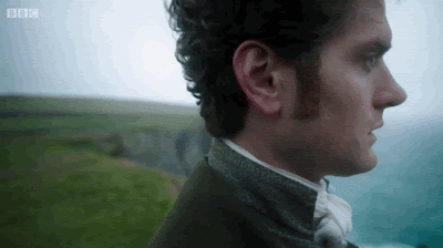 Francis Poldark standing on the cliff edge looking thoughtfully sad