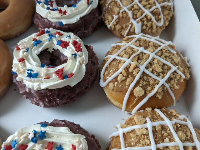 Krispy Kreme Red Velvet Sparkler Donut and All-American Apple Pie Donut close-up.