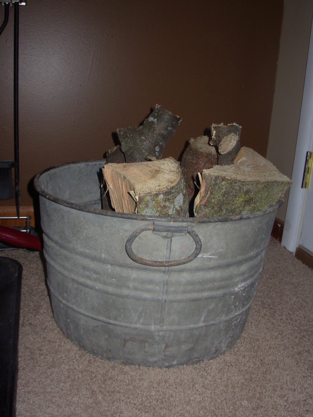 We store firewood in a tin bucket that I found in the barn. title=
