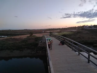 Aim'jie sits on the board walk, our bicycles, dusk.