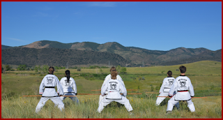 Six black belts doing martial arts at the SMK Black Belt Sympsoium