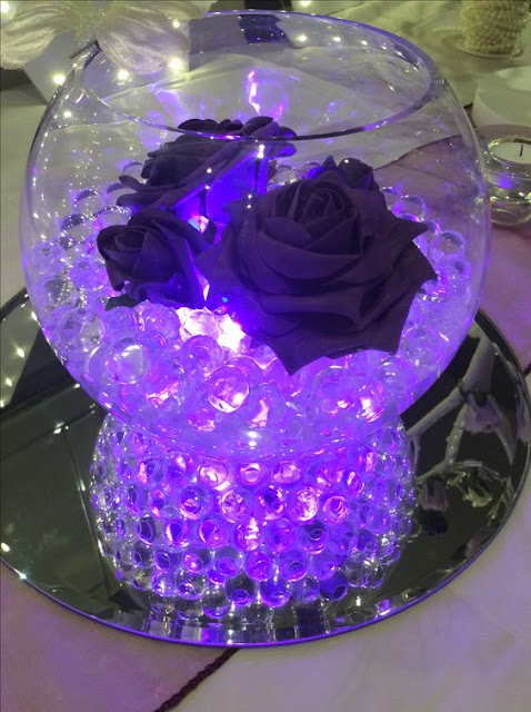 Led Lighting set up with roses for wedding fish bowl masterpiece design with purple aqua crystals