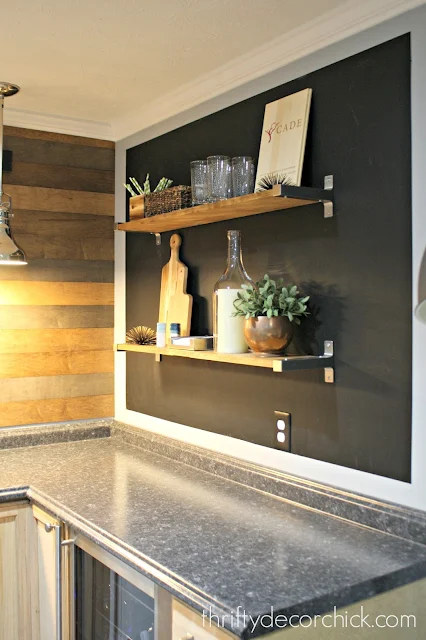 Basement kitchenette with chalkboard wall and shelves