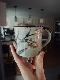 A hand holding a mug