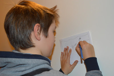 A boy draws ona piece of paper