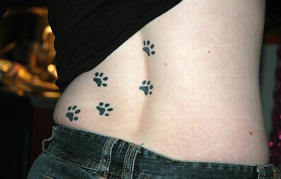 Cat paw print tattoo on girls back