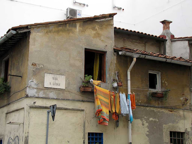 Laundry hanging from a clothesline out of a window in via San Luigi, Livorno