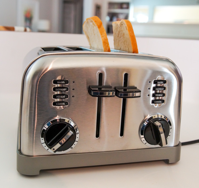 silver two-slice toaster with sourdough bread in slots