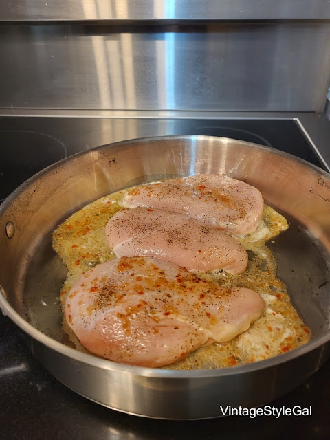 Chicken cooking in skillet over stovetop