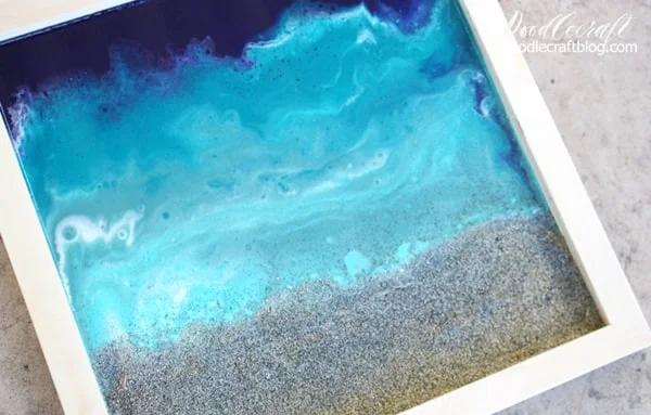 Use glossy resin to make the perfect ocean pour including a little beach sand. Great for beach-inspired home decor.