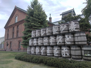 サッポロビール博物館の写真。建物前に並ぶ樽には「 麦とホップを製すればビイルとゆふ酒になる」と書かれている。