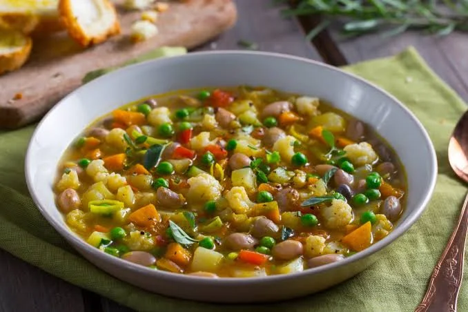 recipiente com minetrone de legumes sobre a mesa