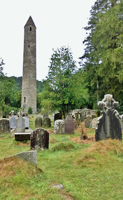 Glendalough Round Tower rises above the tombstones, Glendalough, County Wicklow, Ireland