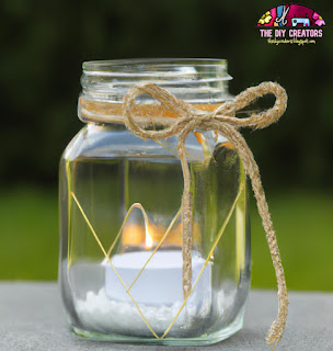 A garden lantern made out of a mason jar with a candle inside