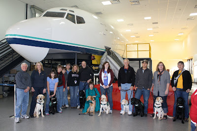 The Eager Eye puppy raising club in front of Alaska Airline's mock-up training aircraft