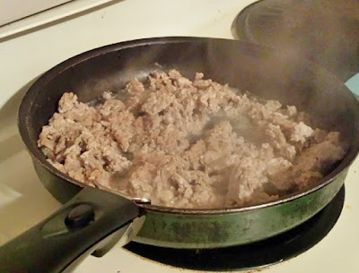 Ground turkey frying in pan.