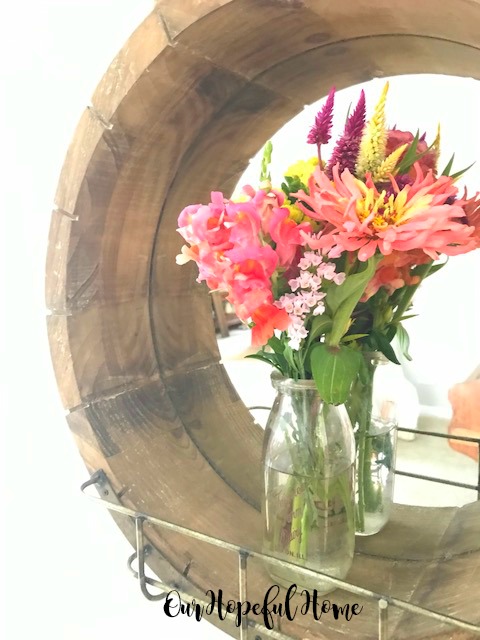 round wooden farmhouse mirror vintage milk bottle vase fresh cut flowers