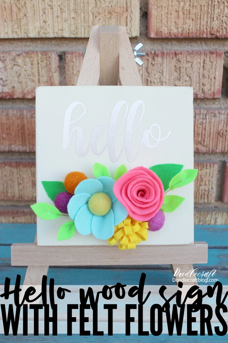 Hello Vinyl Wood Sign with Bright Felt Flowers! Isn't this hello sign perfectly bright and cheery with these colorful felt flowers!? Just a few supplies make this perfect Spring decoration for the mantle, bookshelf or in the entryway. Let me show you how to make felt flowers to add color to a vinyl wood sign for the perfect home decor piece!  It's super simple to make and then options are endless when it comes to adding a greeting.  Let's craft this cute sign in less than an hour!  Make a bunch and sell them at a Spring craft show--they will fly off the shelf!