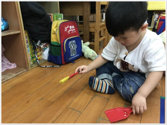 幼兒園孩子用可愛的小掃把道具，幫忙清潔地板。