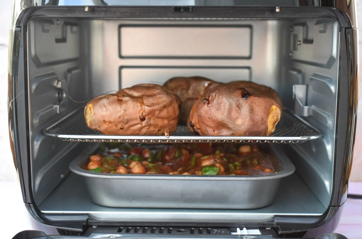 baked potatoes and filling both cooking in an air fryer