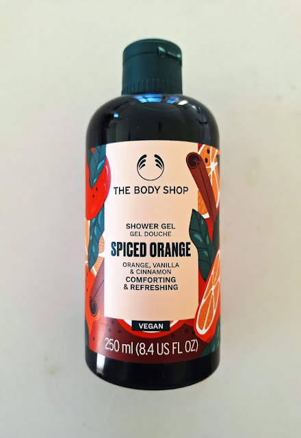 The Body Shop Spiced Orange Shower Gel dark green bottle and font with oranges, cinnamon spices, and leaves on khaki label.