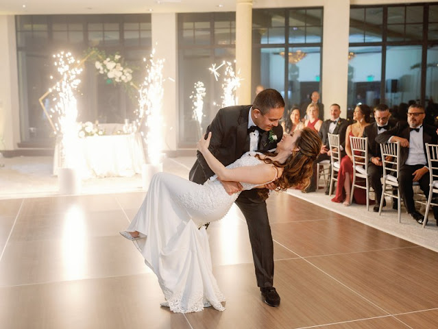 groom dipping bride on dancefloor with cold sparks in background