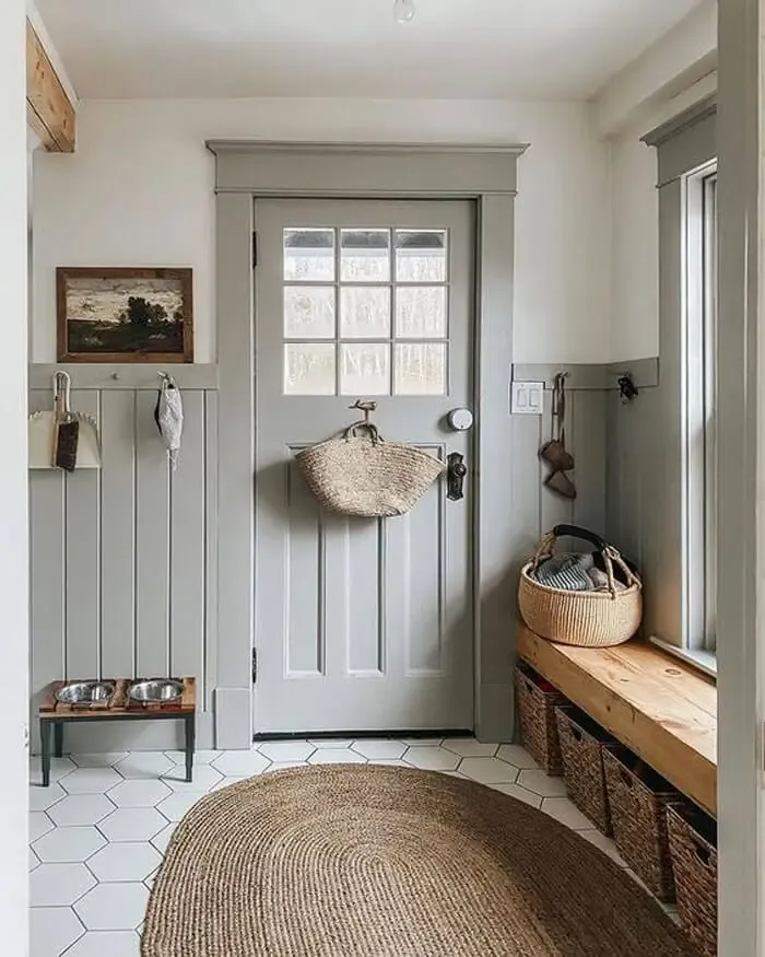 Mudroom with sage green paneling and trim with brick floors