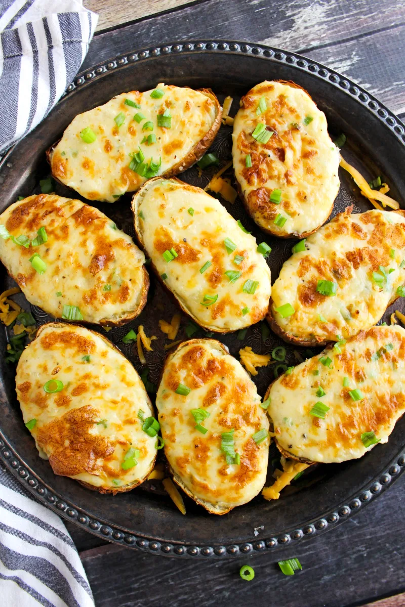 Top view of Air Fryer Twice Baked Potatoes on a grey plate on a wood background.