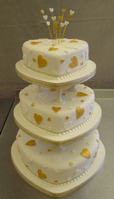 Three seperate tier white heart shaped cake with little white and gold