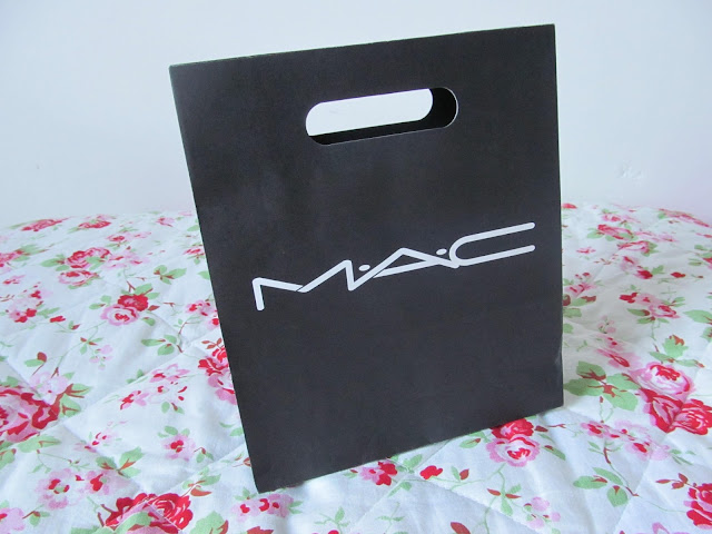 square black paper bag with white text 'MAC'