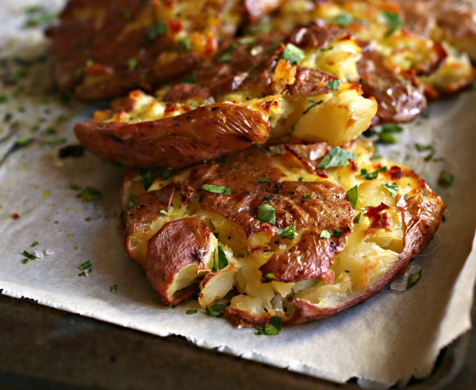 Recipe for crispy, oven smashed potatoes drizzled with a curry olive oil.