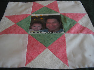 Star square using alternating quarter-square triangle blocks in green, salmon and cream, and center photo.