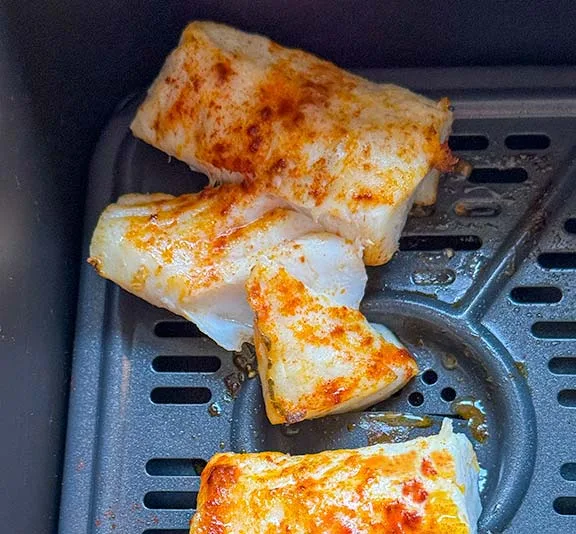Flaky cooked cod in the air fryer.