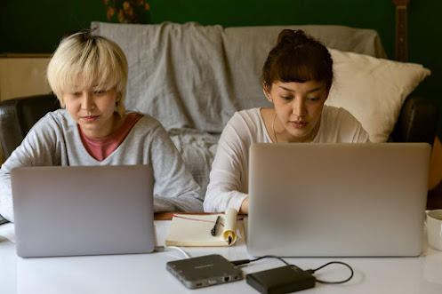 dos jóvenes trabajando por internet