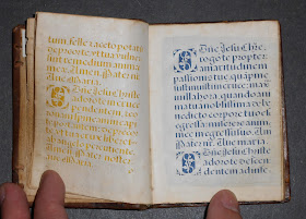 An open book of cut-out text, the lefthand side over yellow silk and the right hand over blue.