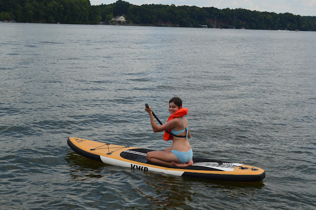 You smiling at the camera while paddling in the water.