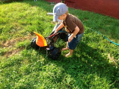 grandson playing with garden hose on the lawn