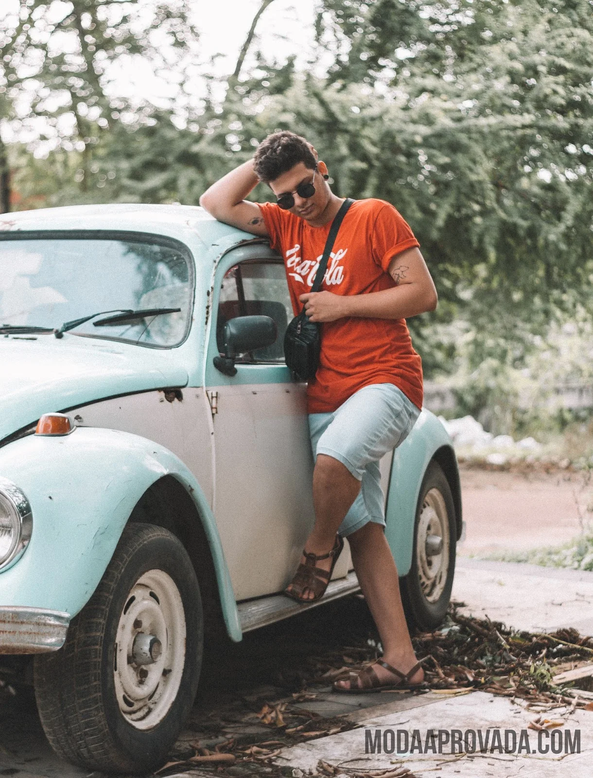 Look Masculino com Pochete, Sandalia de Couro, Camiseta Vermelha, Óculos de Sol