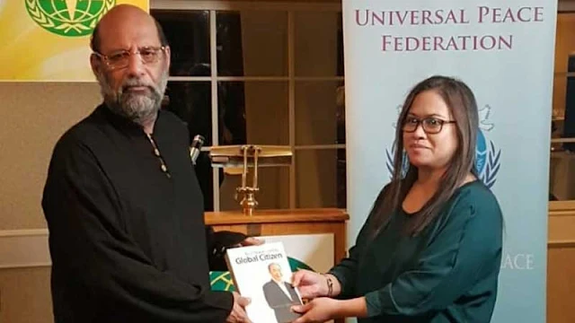 Man with woman receiving a book.