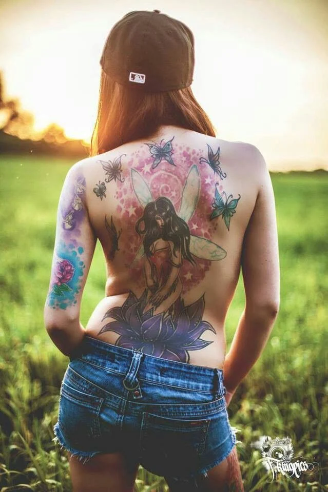 chica de espaldas con tatuaje de flor del loto